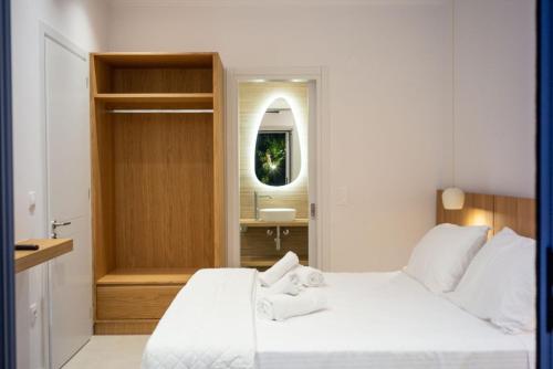 a bedroom with a white bed and a sink at Villa Prado in Almiros Beach