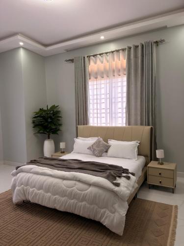 a bedroom with a large bed and a window at Abban homes in Kampala