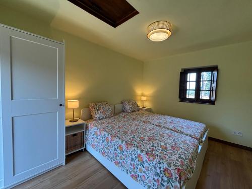 a bedroom with a bed and a window and a door at Casita Madernia in Molledo