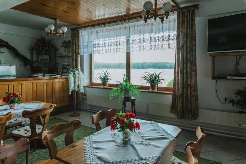 a dining room with a table with flowers on it at Herrmanns-hof in Kronowo