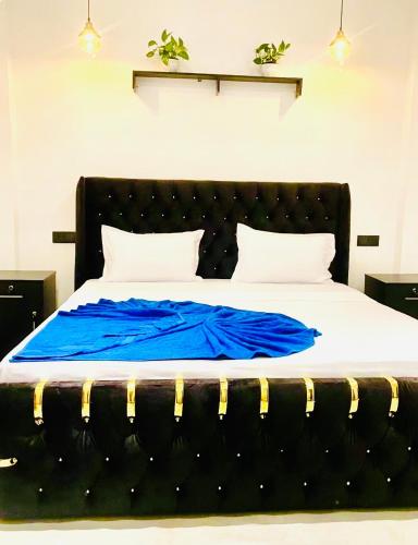 a bed with a blue blanket on top of it at Villa Lithu in Weligama