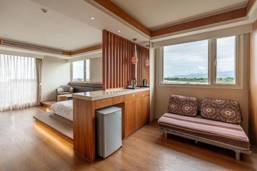 a bedroom with a bed and a couch and windows at 聽風會館 in Yuanshan