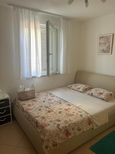 a bedroom with a bed and a window at Apartman Igor in Čižići