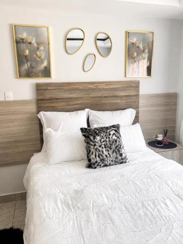 a bedroom with a white bed with mirrors on the wall at Cleopatra Palace in Vereeniging