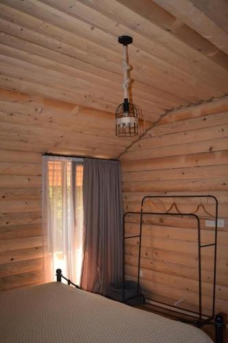 a bedroom with a bed and a window in a log cabin at Keria in Ambrolauri