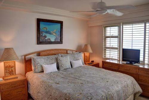 um quarto com uma cama e uma televisão de ecrã plano em Royal Mauian 412 em Kihei