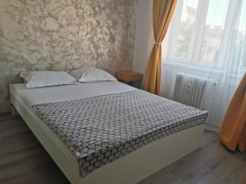 a bedroom with a bed in a room with a window at Apartament Clau Centru Vechi in Constanţa