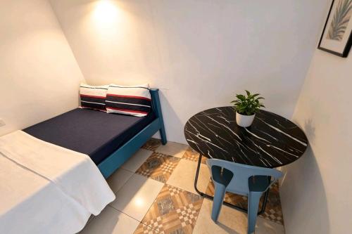 a small room with a bed and a table and a potted plant at B'lu Bamboo in Moalboal