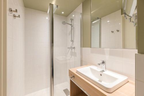 a bathroom with a sink and a shower at Bikube Coliving Hôtel - Lyon Centre Lumière in Lyon