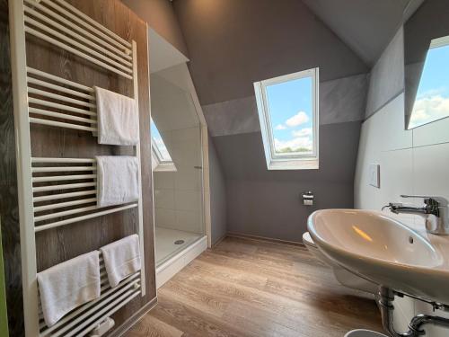 a bathroom with a sink and a toilet and a window at Schlüter Hotel & Restaurant in Wankendorf