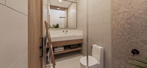 a bathroom with a sink and a toilet and a mirror at The Sultanate Fulhadhoo Baa Atoll in Fulhadhoo