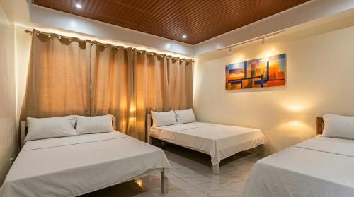 a bedroom with two beds and a painting on the wall at Ysamatti Travel Lodge in Bankal