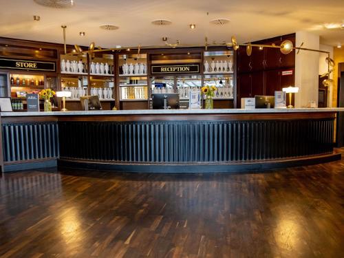 a bar in a restaurant with a wooden floor at Mercure Hotel Frankfurt Airport Langen in Langen