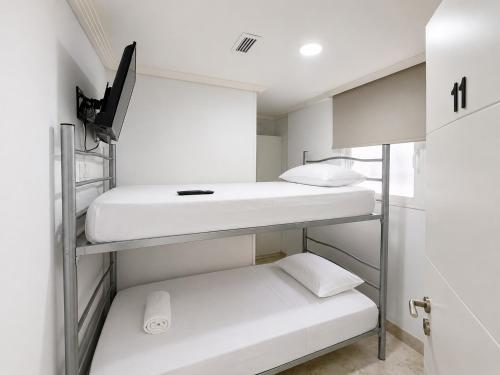 a small room with three bunk beds in it at Hospedaje La Campana in Madrid