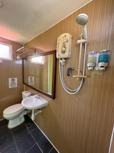 a bathroom with a toilet and a sink and a shower at Papar Beachfront View in Papar