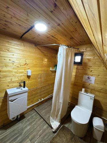 a wooden bathroom with a toilet and a sink at Glamping baytik in Verkhnyaya Alaarcha
