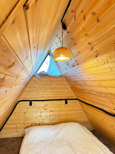 a bed in a wooden room with a window at Glamping baytik in Verkhnyaya Alaarcha