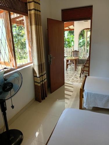 a bedroom with a bed and a door leading to a patio at Muthu Villa in Kalutara