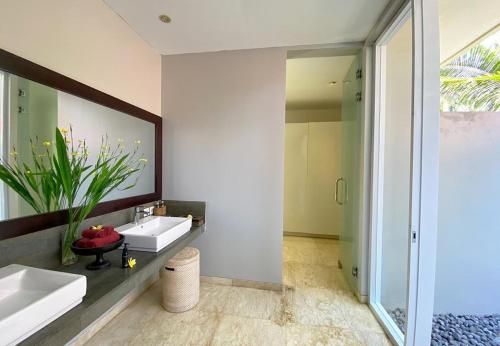 a bathroom with two sinks and a mirror at Kelapa Retreat and Spa in Pulukan