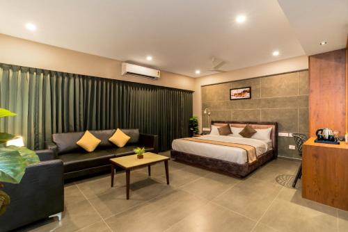 a hotel room with a bed and a couch at Neelagiri Heritage Hotel - Near Calicut Railway Station in Kozhikode