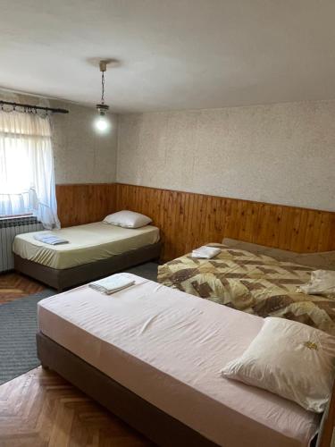 a bedroom with two beds and a window at Yellow House in Ritopek