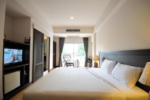a hotel room with a bed and a television at Kasemsarn Hotel Chanthaburi in Chanthaburi
