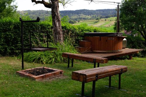 a picnic table and bench next to a fire pit at Pod Dzwonkiem in Jasienica