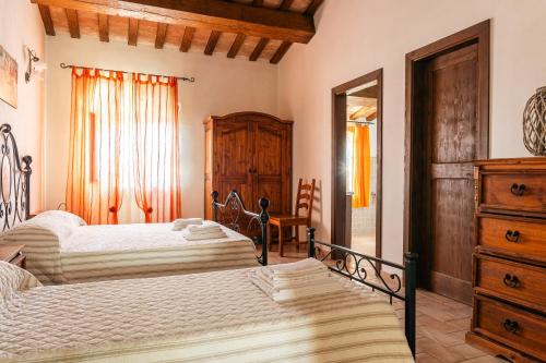a bedroom with two beds and a dresser at Agriturismo Fontesomma in Apecchio