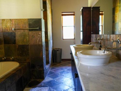 a bathroom with a tub and a toilet and a sink at Lucca Lodge in Linton
