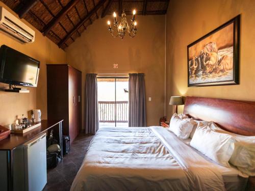 a bedroom with a large bed and a chandelier at Lucca Lodge in Linton