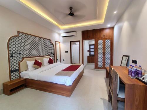 a bedroom with a king sized bed and a desk at MVT Guesthouse & Restaurant in Vrindāvan