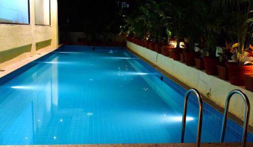 duży niebieski basen w budynku w obiekcie The Flora Grand, Vasco, Goa w mieście Vasco Da Gama