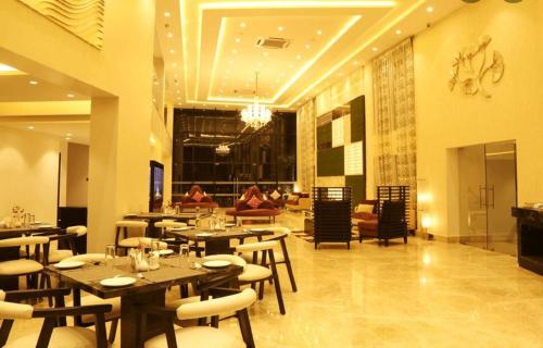 瓦斯科达伽马The Flora Grand, Vasco, Goa的一间有桌椅的餐厅