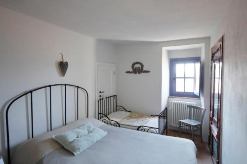a white bedroom with a bed and a window at Casa Fernanda in Albiano