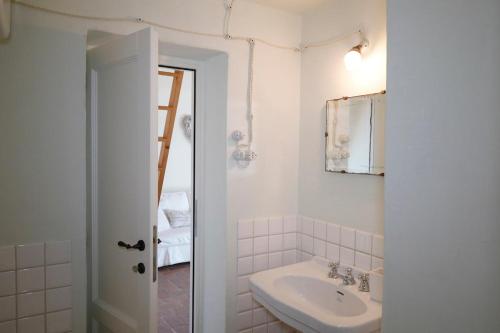 a white bathroom with a sink and a mirror at Casa Fernanda in Albiano