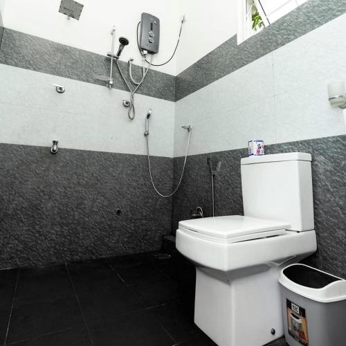 a bathroom with a toilet and a phone on the wall at Villa Akeinya in Matara