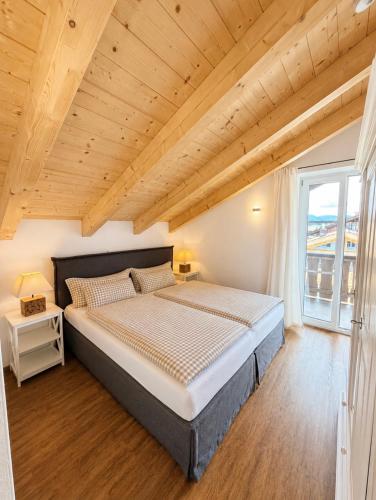 a bedroom with a large bed with a wooden ceiling at Alpenwohnung Neuner in Wallgau