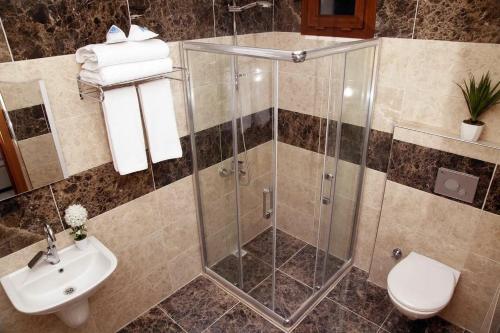 a bathroom with a shower and a toilet and a sink at FAVORİTE Hotel in Söğütlü
