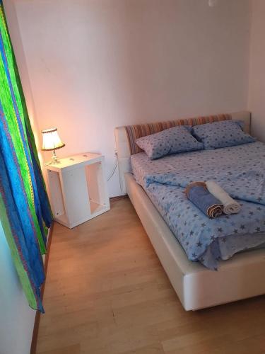 a bedroom with a bed and a night stand with a lamp at Vikendica Emily in Kovin