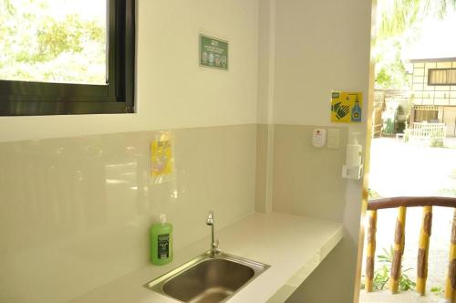 a bathroom with a sink and a window at Paseo Verde Beach Resort in Laiya