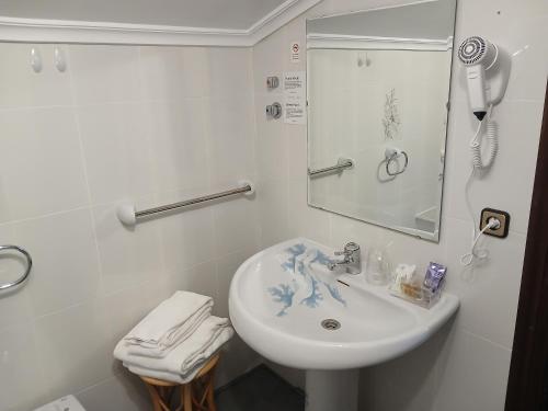 a white bathroom with a sink and a mirror at Hosteria De Quijas in Quijas