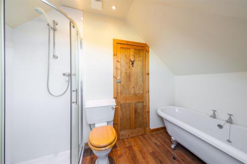 a bathroom with a toilet and a bath tub at Meadowview in Lochearnhead