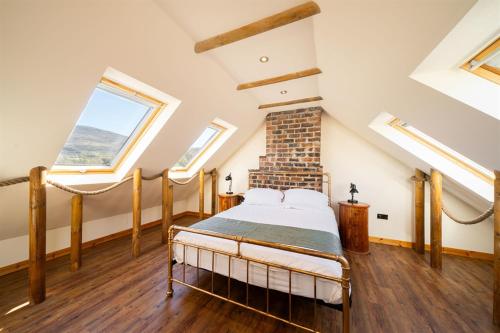 a bedroom with a bed in a room with skylights at Meadowview in Lochearnhead