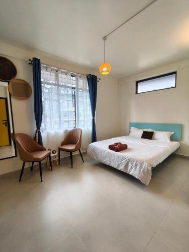 a bedroom with a large bed and two chairs at Urbanest B&B in Shillong