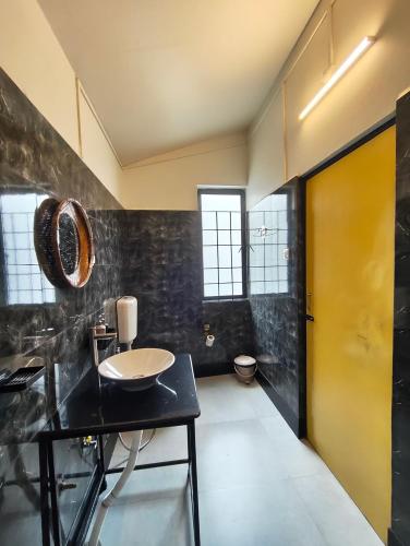 a bathroom with a sink and a yellow door at Urbanest B&B in Shillong