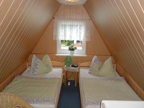 ein Dachzimmer mit zwei Betten und einem Fenster in der Unterkunft Ferienpark Rosstrappe in Thale