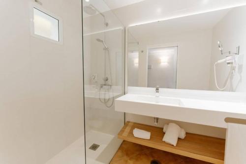 a white bathroom with a sink and a shower at R2 Buganvilla Hotel & Spa in Morro del Jable