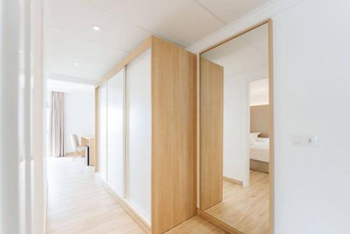 a large mirror in a room with a bedroom at R2 Buganvilla Hotel & Spa in Morro del Jable