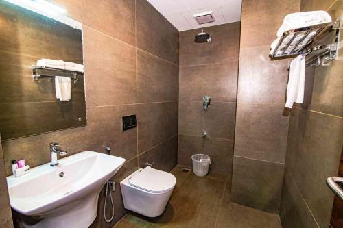 a bathroom with a sink and a toilet at Neelagiri Heritage Hotel - Near Calicut Railway Station in Kozhikode