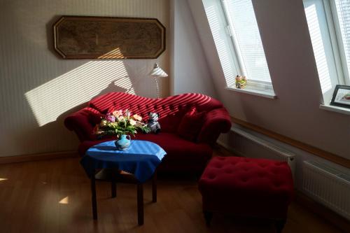 a living room with a red couch and a table at Stadtflitzerbude in Dresden